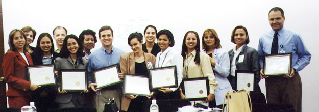Image of a large group of participants with framed certificates from the Coaching & Feedback class.