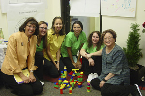 Image of six women on the floor posed with a construction blocks activity.
